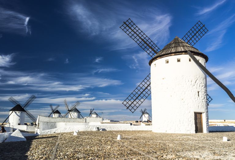 Picturesque scene of traditional Spanish windmills under a blue sky.